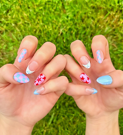 Hand-Painted press-on nails with various colorful, bright nail art in red, light pink, and light blue colors. The press-on nail designs include stars, blueberries, dots, and checkers. 