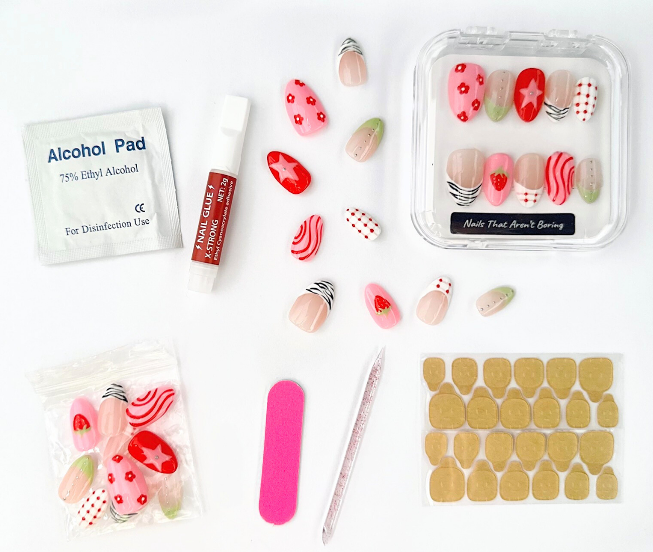 Hand-Painted luxury press on nail kit for NTAB Strawberry Picnic nails. Nail kit contents are displayed including 24 press on nails in a box, alcohol pad, adhesive tabs, nail glue, nail file, and cuticle stick. 